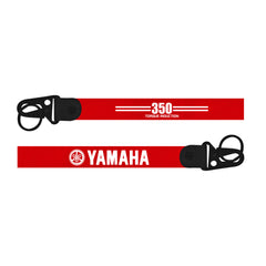Red Yamaha chainsaw strap with black handles on a white background